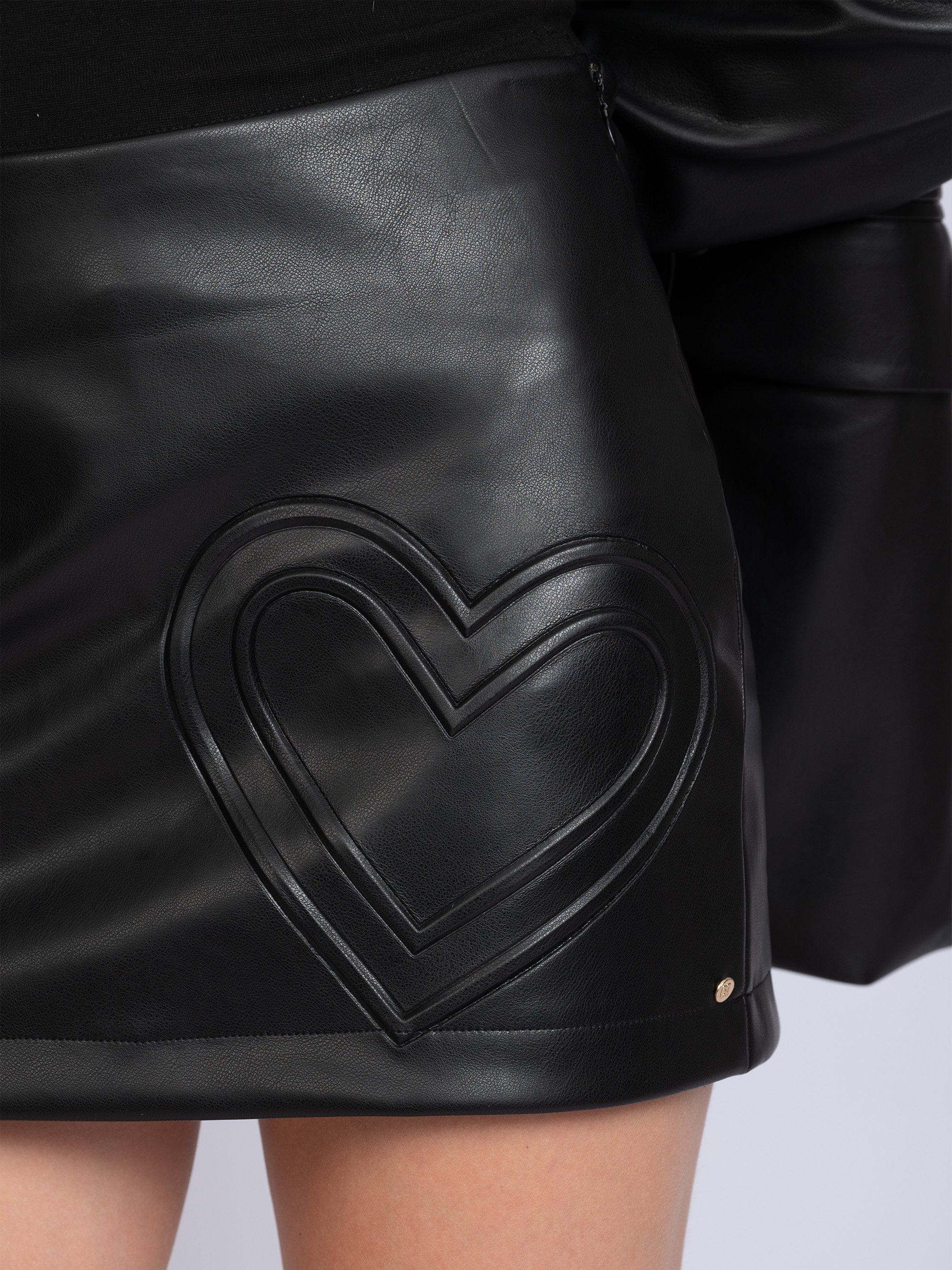 Short skort made of faux leather with heart detail