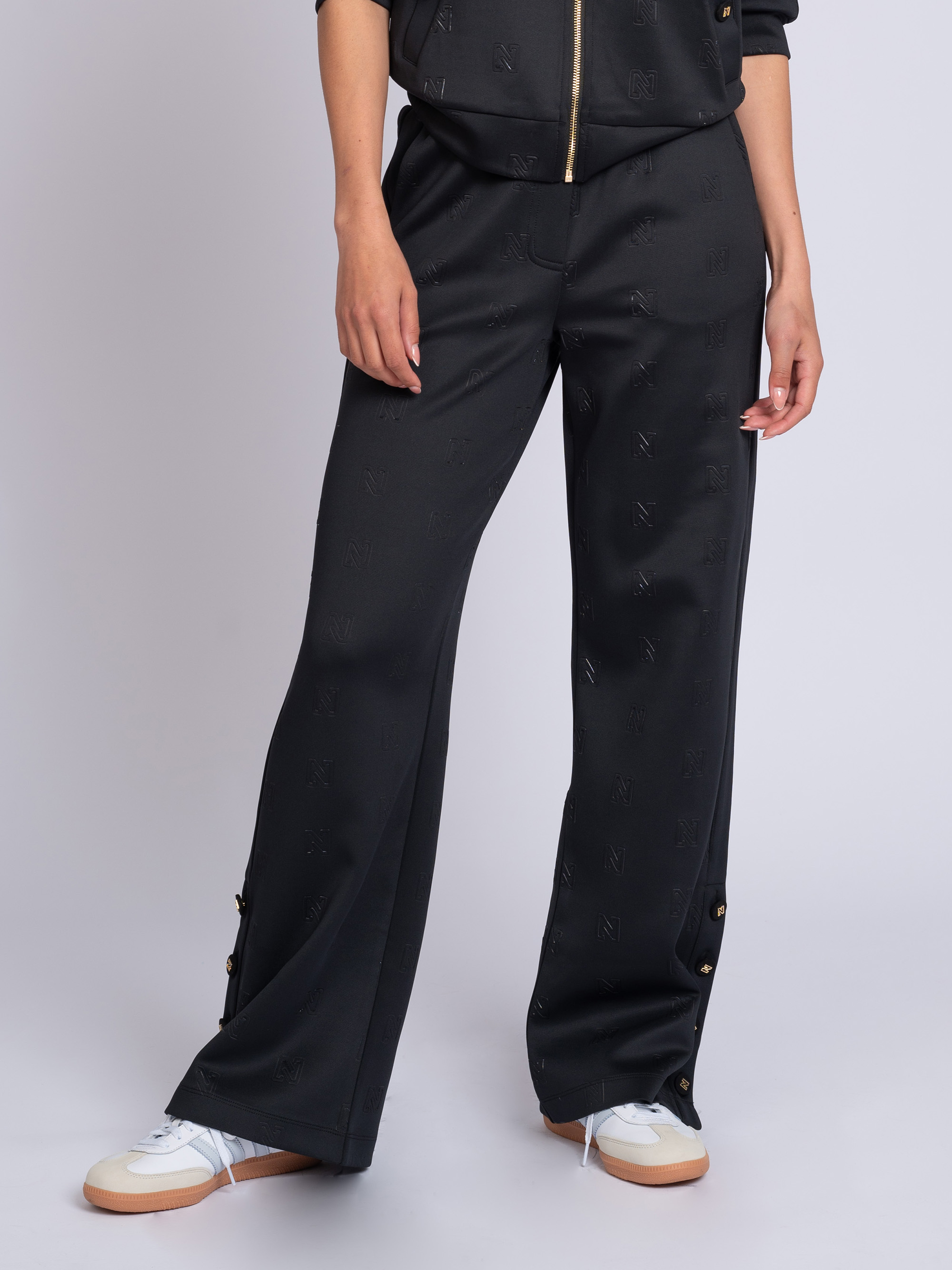 Losvallende broek met logo patroon en sierknopen